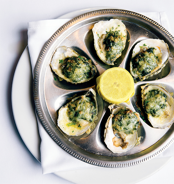 Oysters with herb and butter sauce on silver platter