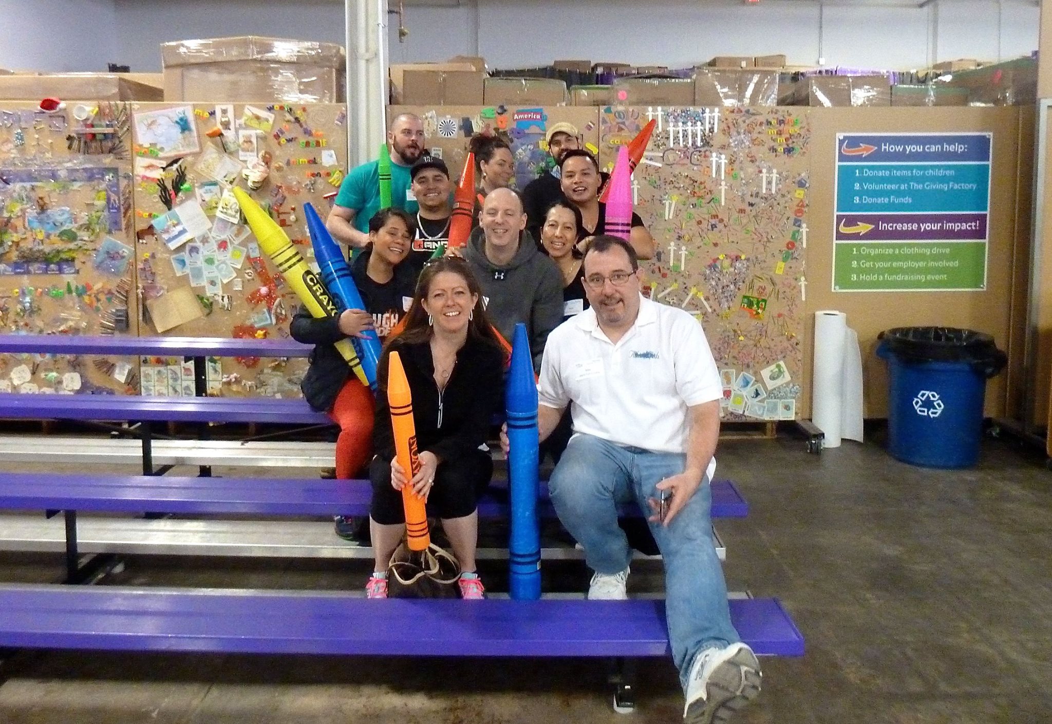 group of people holding large crayons